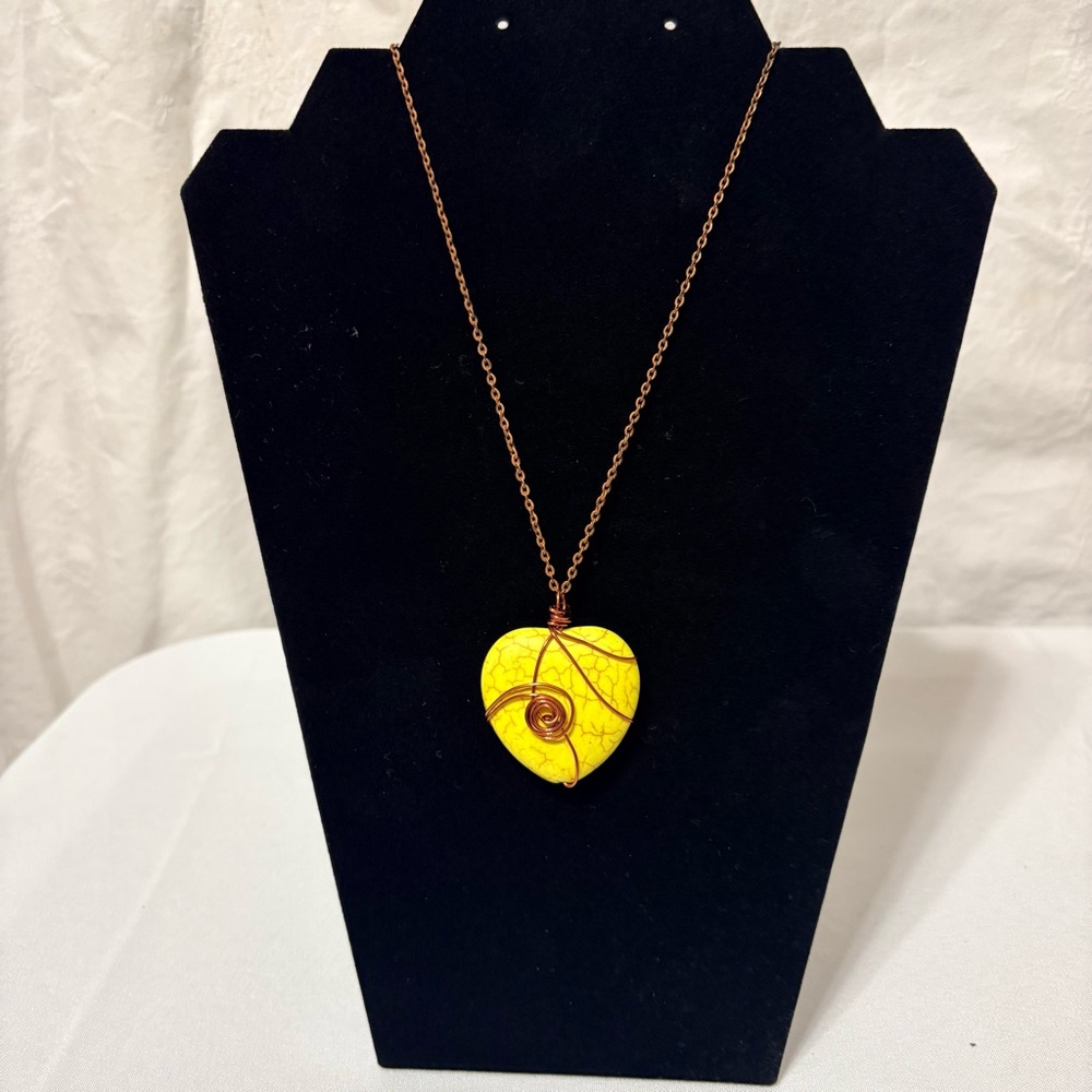 yellow stone heart pendant necklace with a copper-tone wire wrap and chain.